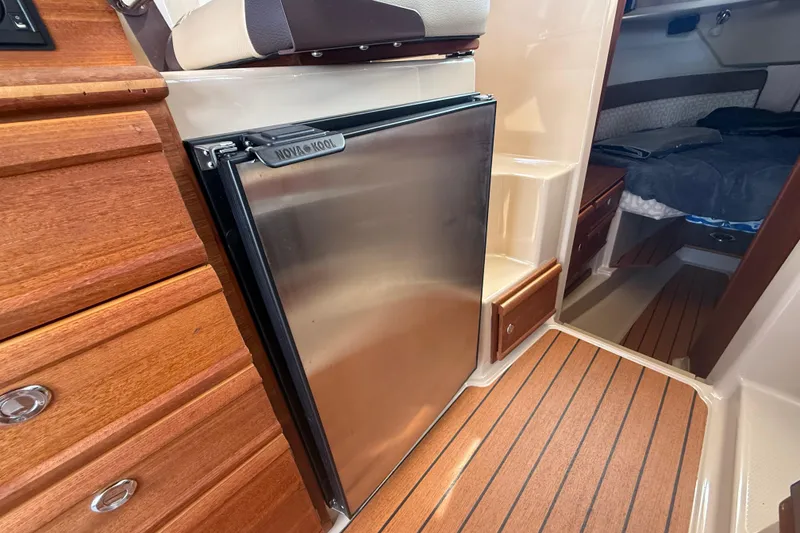 Slide: The Image of 2019 Ranger Tugs R-27 interior with Nova Kool fridge and wood cabinetry. - 22