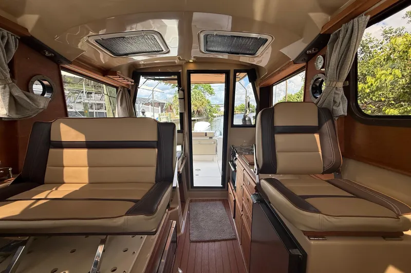 Slide: The Image of Interior of 2019 Ranger Tugs R-27 boat with tan seating and wood accents. - 25