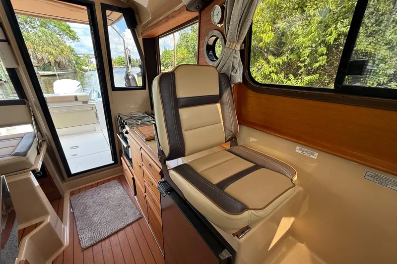 Slide: The Image of Interior of 2019 Ranger Tugs R-27 boat with seating and scenic window view. - 26
