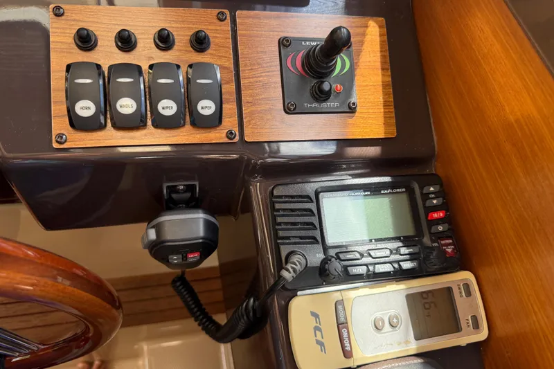 Slide: The Image of Control panel of a 2019 Ranger Tugs R-27 boat with switches and communication devices. - 32