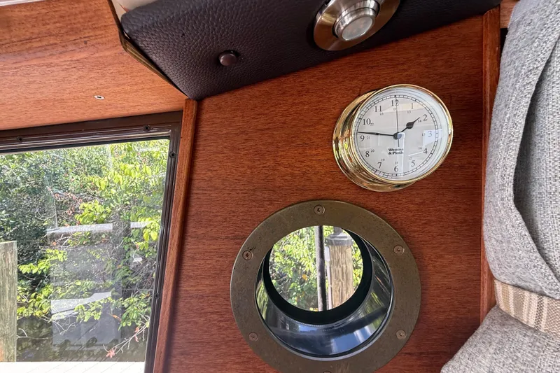 Slide: The Image of Interior of 2019 Ranger Tugs R-27 with clock and porthole, wooden paneling visible. - 36