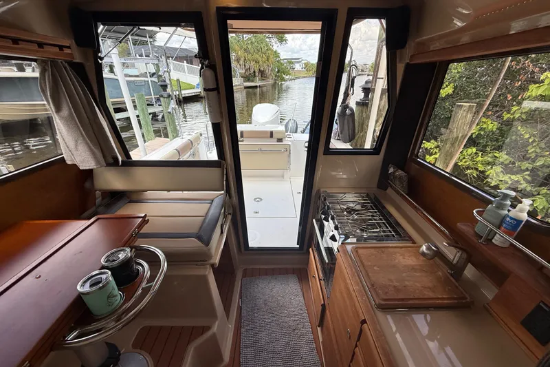 Slide: The Image of Interior of 2019 Ranger Tugs R-27 boat with kitchen and seating area. - 37