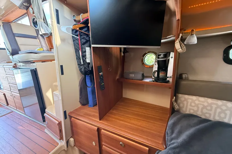Slide: The Image of 2019 Ranger Tugs R-27 interior with TV, coffee maker, and cozy seating area. - 39