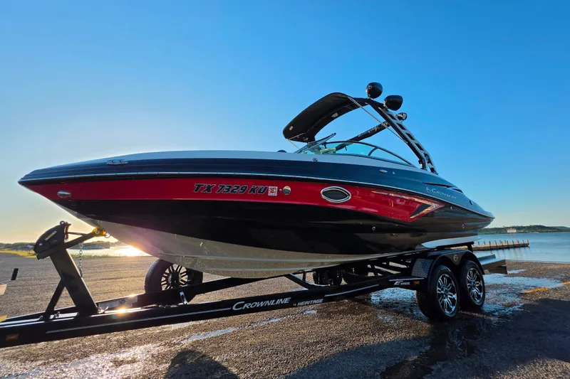 The Image of 2024 Crownline Eclipse E255 SURF boat on trailer by the water at sunrise. - 1