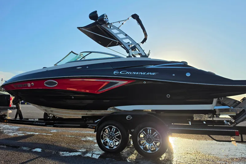 Slide: The Image of 2024 Crownline Eclipse E255 SURF boat on trailer, sleek black and red design. - 3