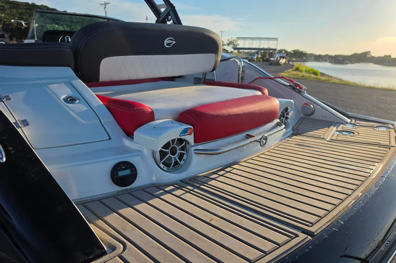 Slide: The Image of 2024 Crownline Eclipse E255 SURF boat with stylish seating and modern design by the water. - 4