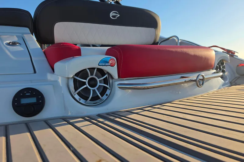 Slide: The Image of 2024 Crownline Eclipse E255 SURF boat interior with red and white seating, speaker, and control panel. - 5