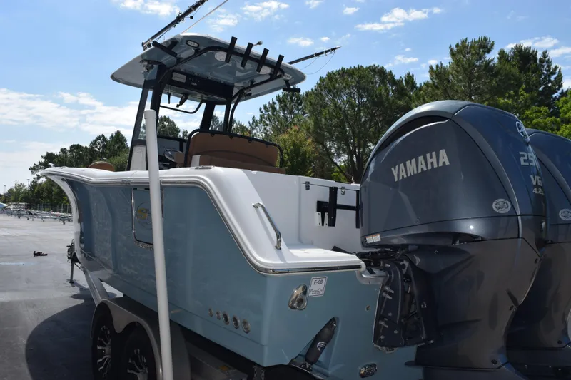 Slide: The Image of 2022 Sea Hunt Gamefish 27 boat with Yamaha engines, parked outdoors under a clear sky. - 6