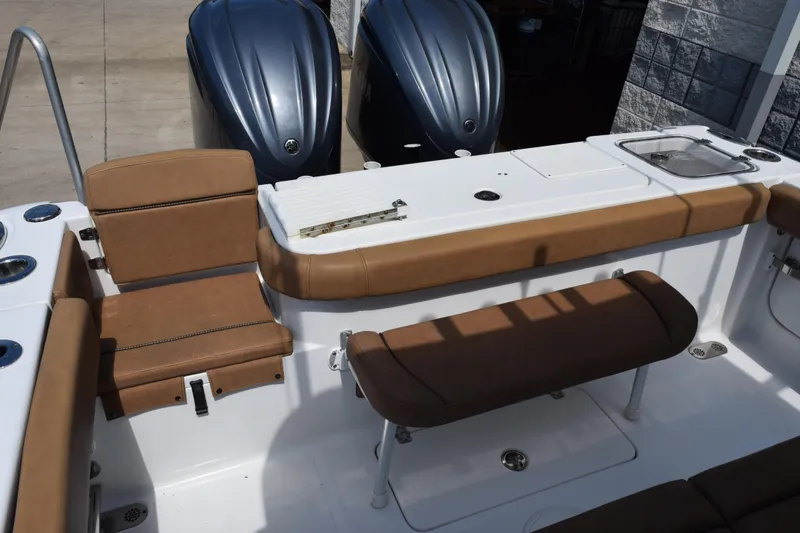 Slide: The Image of 2022 Sea Hunt Gamefish 27 boat interior with brown seating and dual engines. - 9
