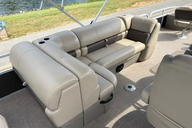 Slide: The Image of 2022 Sun Tracker Fishin' Barge 22 XP3 interior with beige seating and cup holders. - 18