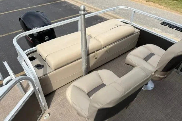 Slide: The Image of 2022 Sun Tracker Fishin' Barge 22 XP3 interior with beige seating and motor view. - 19