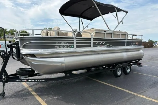 Slide: The Image of 2022 Sun Tracker Fishin' Barge 22 XP3 pontoon boat on trailer, parked outdoors. - 3