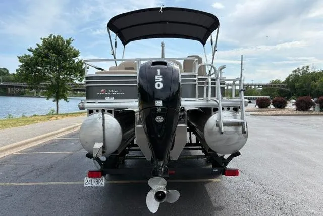 Slide: The Image of 2022 Sun Tracker Fishin' Barge 22 XP3 pontoon boat with outboard motor, parked near a lake. - 7