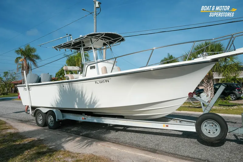 The Image of 2015 Parker 2801 Center Console boat on trailer, parked on a sunny street. - 0