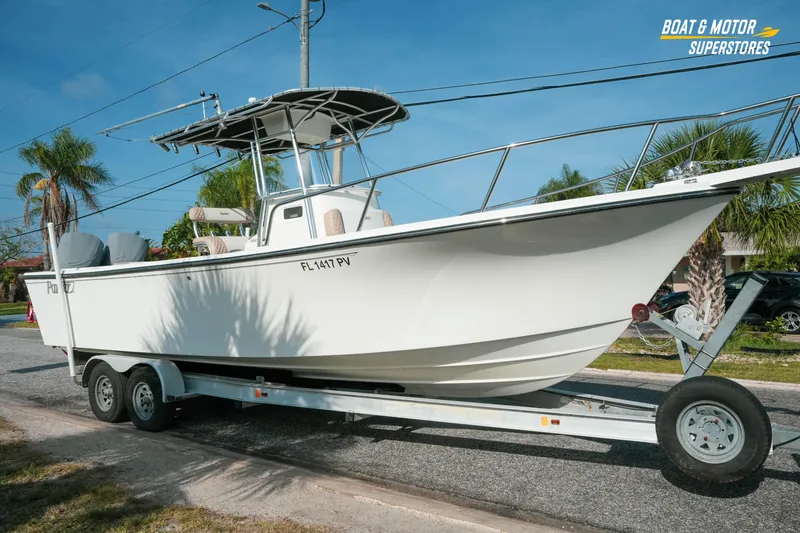 Slide: The Image of 2015 Parker 2801 Center Console boat on trailer, parked roadside under clear blue sky. - 13