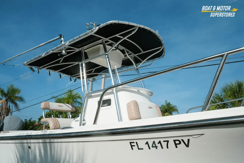 Slide: The Image of 2015 Parker 2801 Center Console boat with canopy, displayed outdoors under clear blue sky. - 14