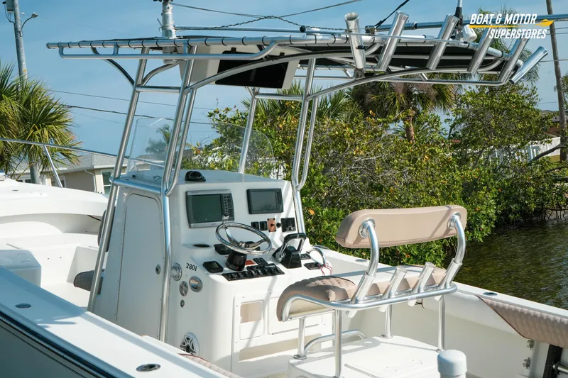 Slide: The Image of 2015 Parker 2801 Center Console boat with modern controls and seating, docked near lush greenery. - 20