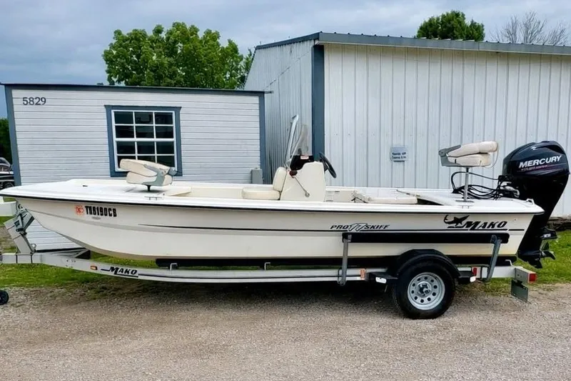 The Image of 2013 Mako Pro Skiff 17 CC boat on trailer, parked near a building. - 0