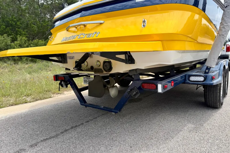 Slide: The Image of 2009 MasterCraft X30 boat on trailer, showcasing rear view and propeller. - 13