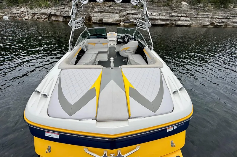 Slide: The Image of 2009 MasterCraft X30 boat with stylish seating, docked on a serene lake. - 17