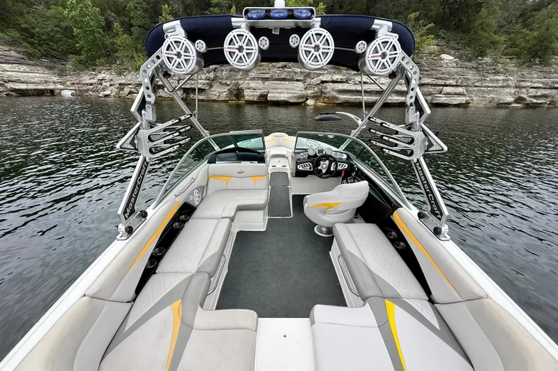 Slide: The Image of 2009 MasterCraft X30 boat interior with sleek seating and advanced audio system on a lake. - 18