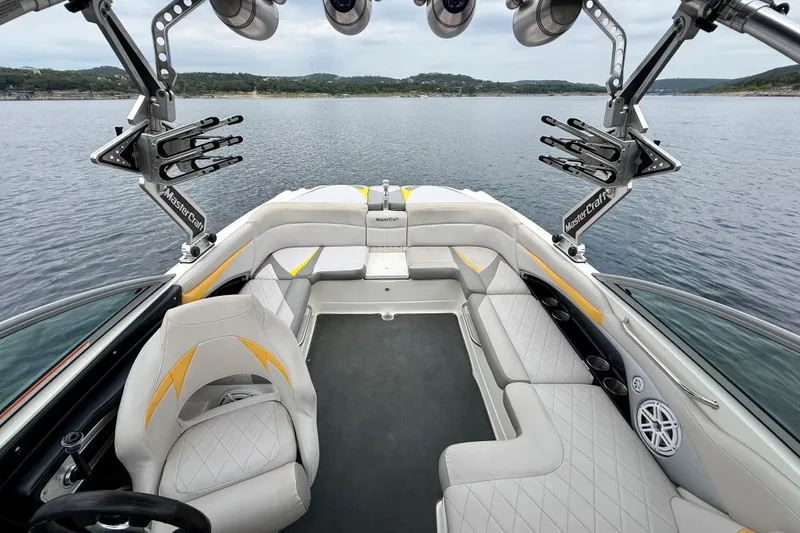 Slide: The Image of 2009 MasterCraft X30 boat interior with luxurious seating and wakeboard racks on a serene lake. - 21