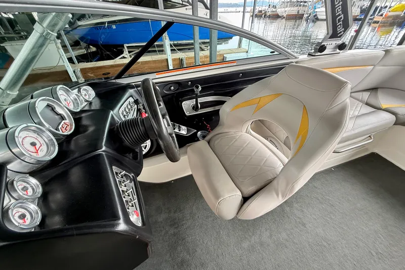 Slide: The Image of 2009 MasterCraft X30 boat interior with steering wheel, gauges, and cushioned seating. - 23