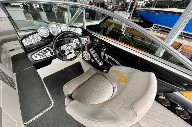 Slide: The Image of 2009 MasterCraft X30 boat interior with steering wheel, dashboard, and captain's seat. - 24