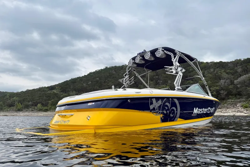 Slide: The Image of 2009 MasterCraft X30 boat on water with scenic hillside background. - 4