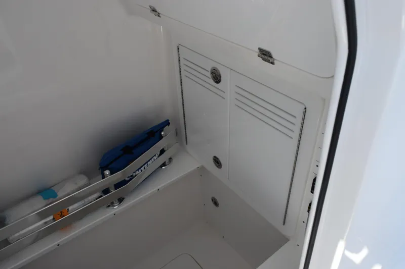 Slide: The Image of 2026 Contender 32 ST boat storage compartment with secure latch and organized interior. - 20
