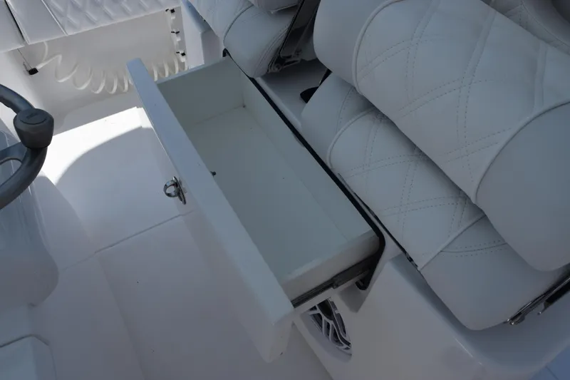 Slide: The Image of Open storage drawer in 2026 Contender 32 ST boat with white seating. - 24
