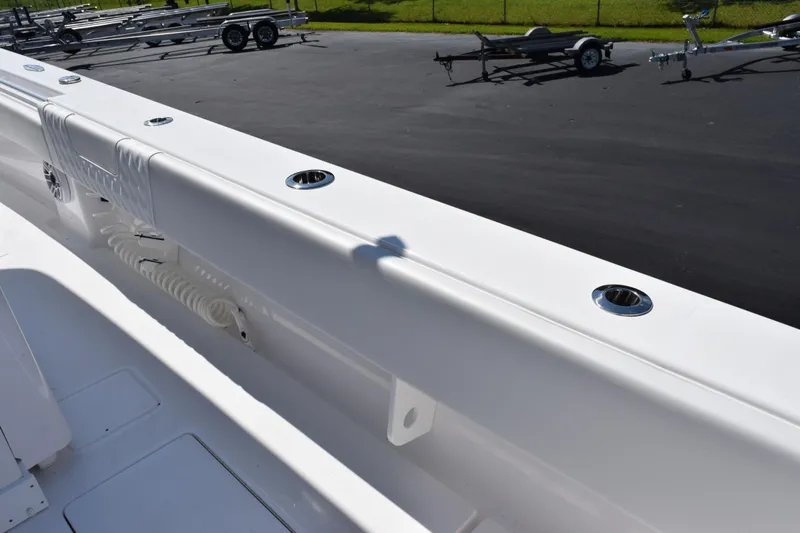Slide: The Image of 2026 Contender 32 ST boat deck with rod holders and coiled hose, parked on asphalt. - 33