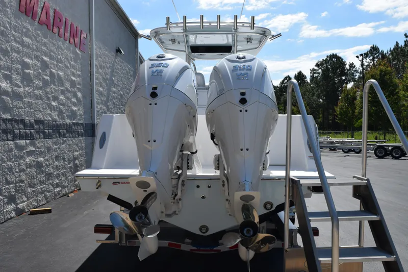 Slide: The Image of 2026 Contender 32 ST boat with dual outboard engines, parked near a marine facility. - 5