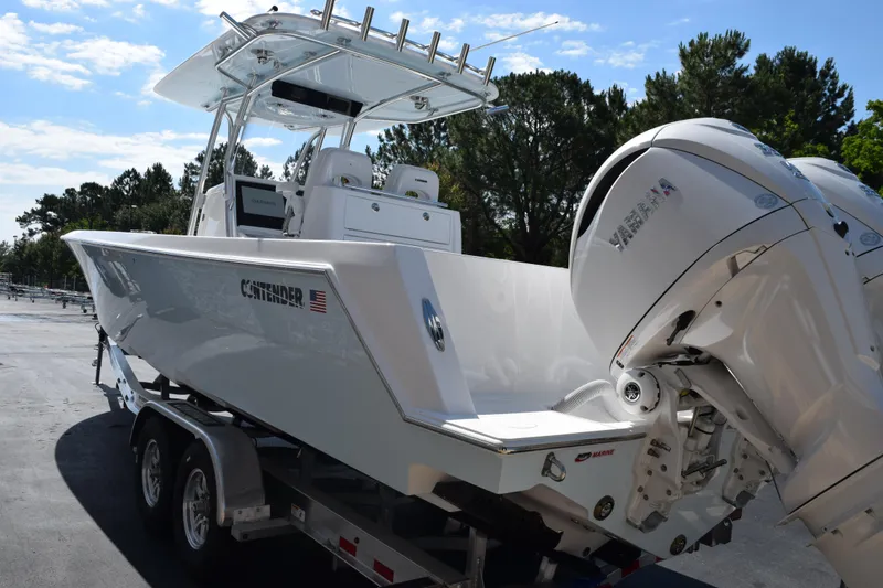 Slide: The Image of 2026 Contender 32 ST boat with Yamaha engines on a trailer, parked outdoors. - 6