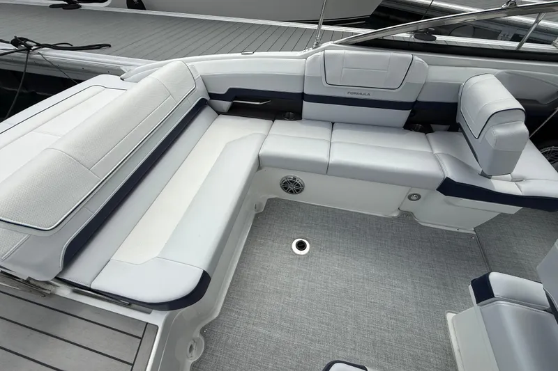 Slide: The Image of 2024 Formula 270 Bowrider interior with white and navy seating, docked at marina. - 9