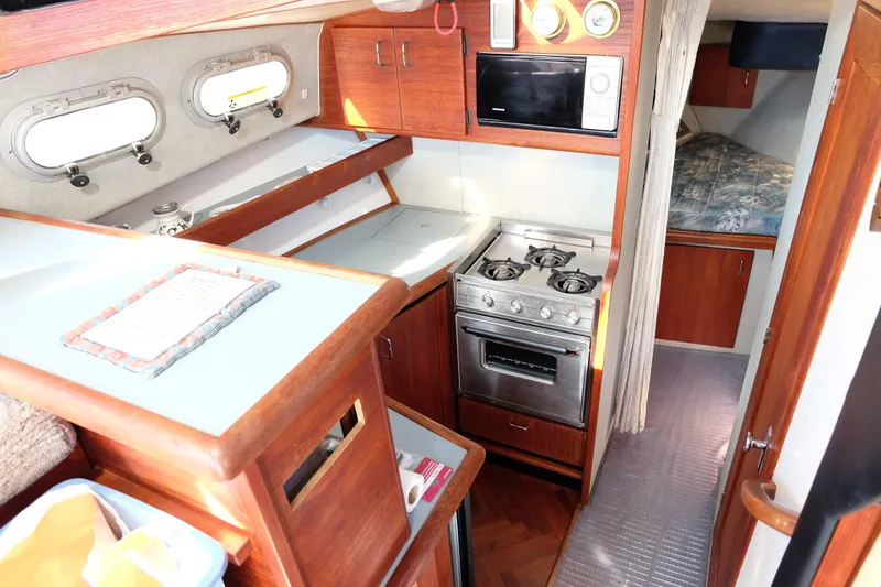 Slide: The Image of Step down into galley, stainless sink, oven, microwave and refrigerator. - 12