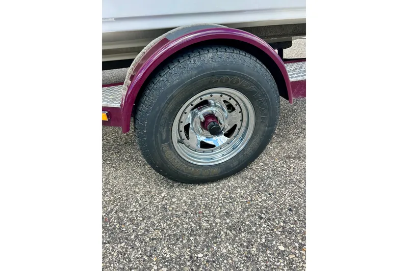 Slide: The Image of Trailer wheel of a 2007 Crownline 180 BR boat on a textured surface. - 16