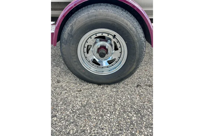 Slide: The Image of Close-up of a 2007 Crownline 180 BR trailer wheel on asphalt surface. - 18