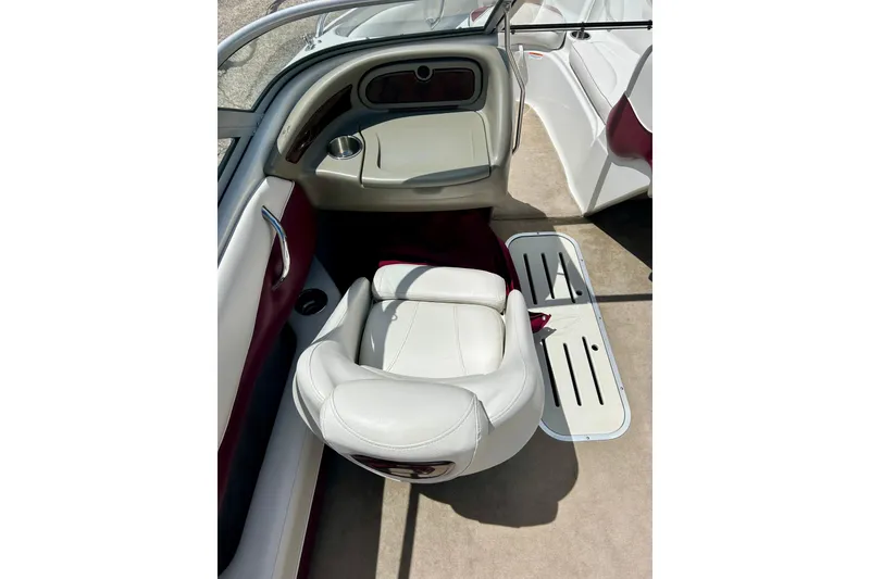 Slide: The Image of 2007 Crownline 180 BR boat interior with white and maroon seating, cup holder, and carpeted floor. - 21