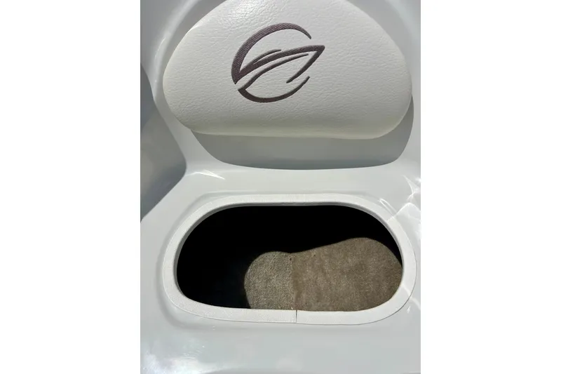 Slide: The Image of 2007 Crownline 180 BR boat storage compartment with logo on white cushioned seat. - 27