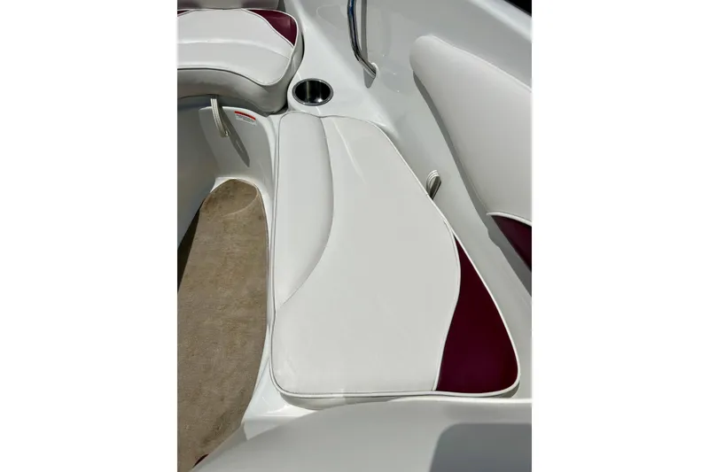 Slide: The Image of 2007 Crownline 180 BR boat interior with white and maroon seating and cup holder. - 28