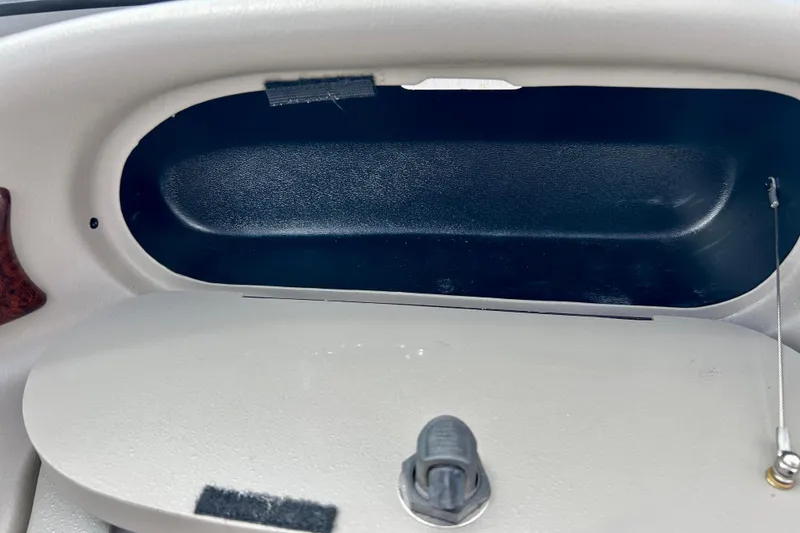 Slide: The Image of Dashboard compartment of a 2007 Crownline 180 BR boat, featuring a latch and cable. - 45