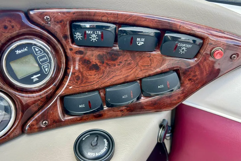 Slide: The Image of Dashboard controls of a 2007 Crownline 180 BR boat with wood finish and MP3 input. - 46