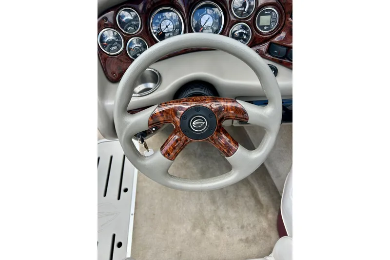 Slide: The Image of Steering wheel and dashboard of 2007 Crownline 180 BR boat, featuring wood accents and gauges. - 47