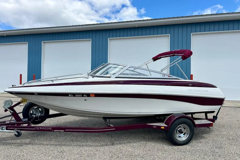 Slide: The Image of 2007 Crownline 180 BR boat on trailer, parked outside blue building. - 50