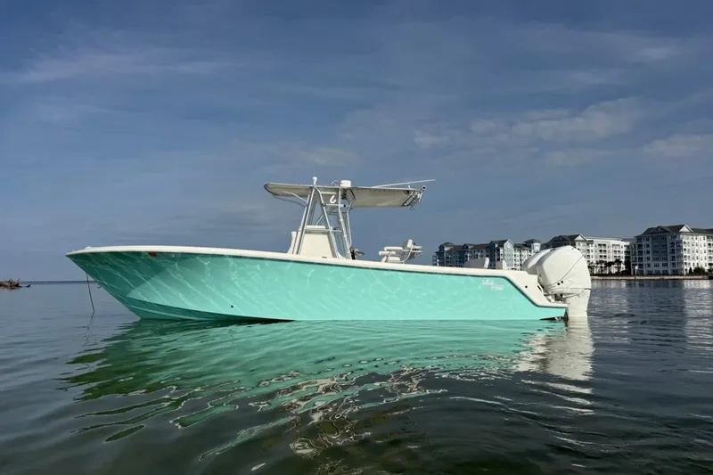 The Image of 2014 SeaVee 290B boat on calm water with coastal buildings in the background. - 0