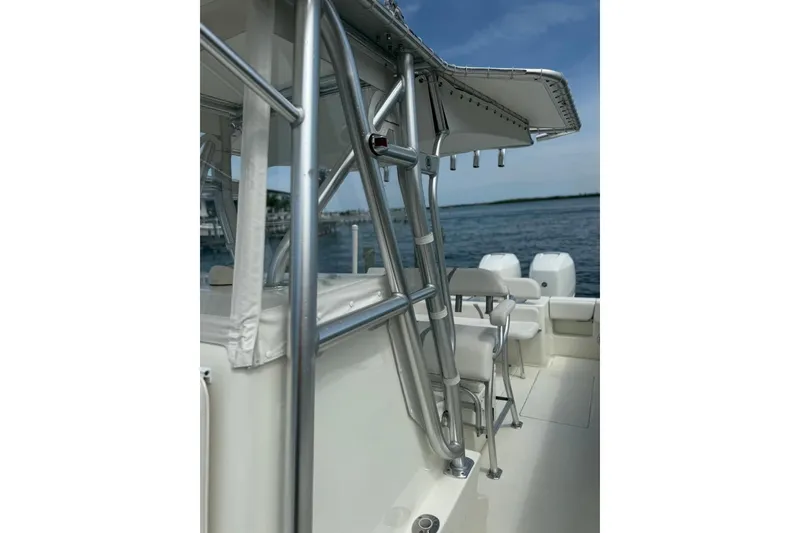 Slide: The Image of 2014 SeaVee 290B boat with sleek metal framework and seating, docked by the water. - 11