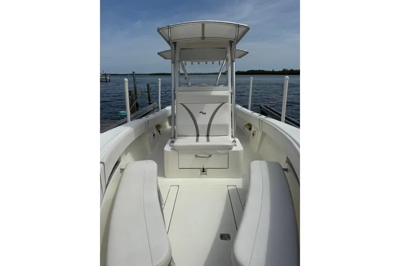 Slide: The Image of 2014 SeaVee 290B boat interior with seating, docked by calm waters. - 16