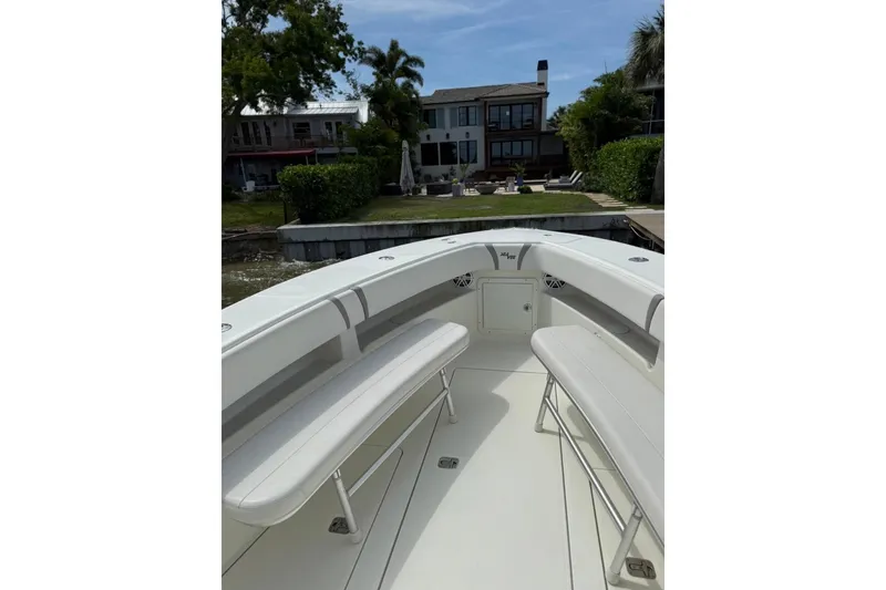Slide: The Image of 2014 SeaVee 290B boat interior with seating, docked near waterfront homes. - 18