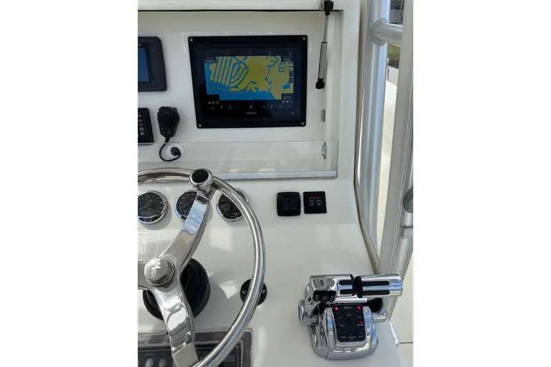 Slide: The Image of 2014 SeaVee 290B helm with GPS display, steering wheel, and throttle controls. - 2